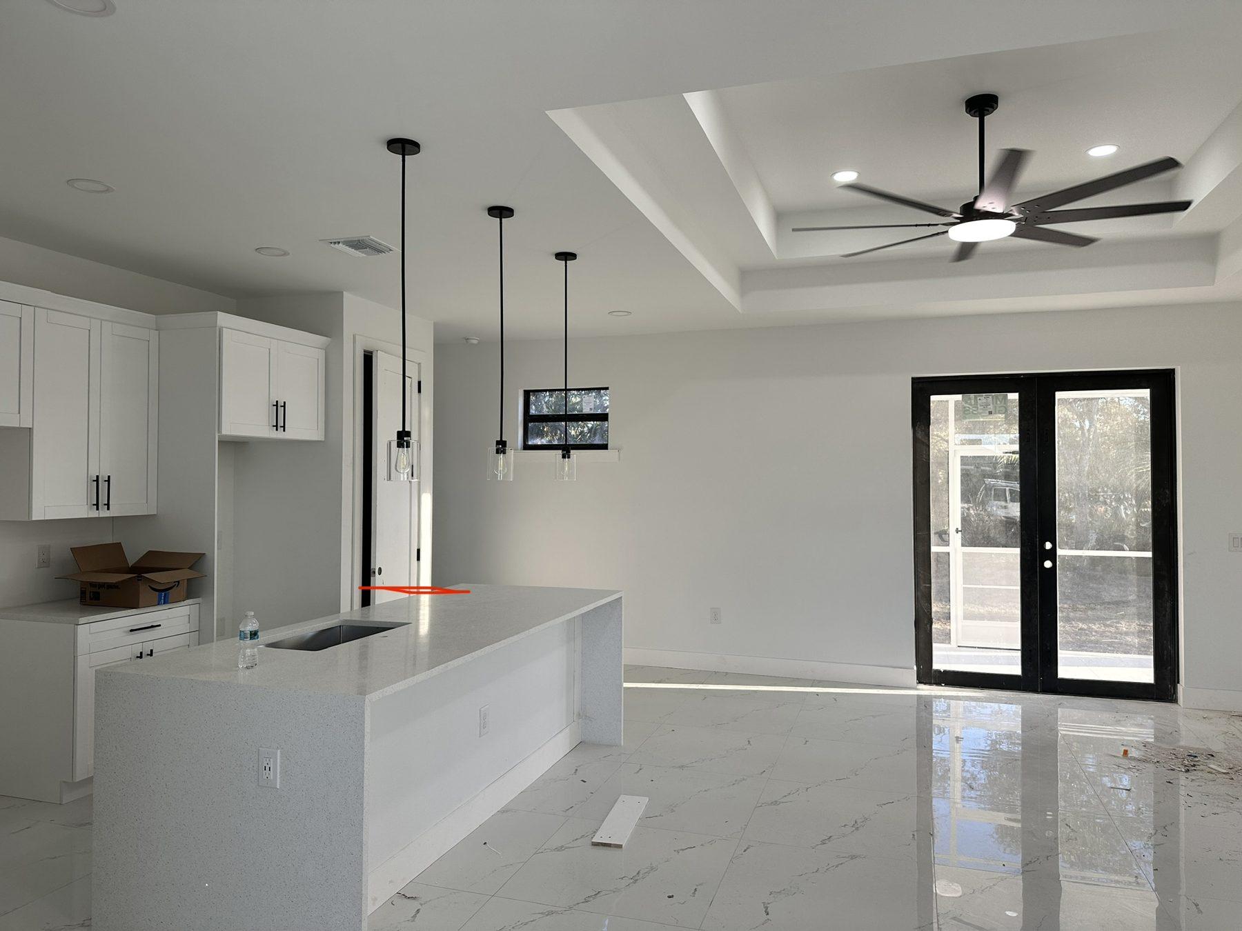 Open living room and kitchen with pendant lights and tray ceiling