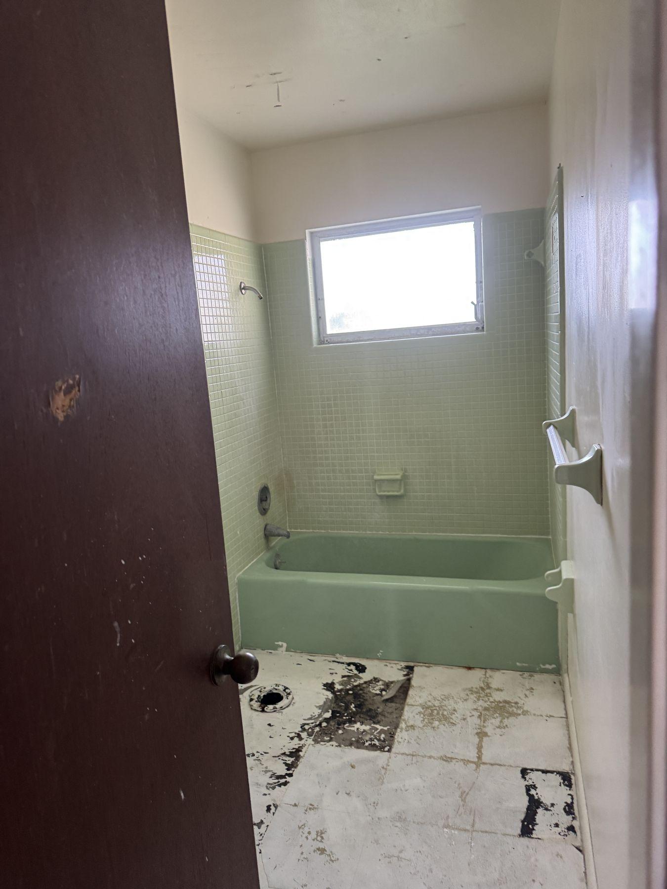Dated bathroom with green tub before remodel