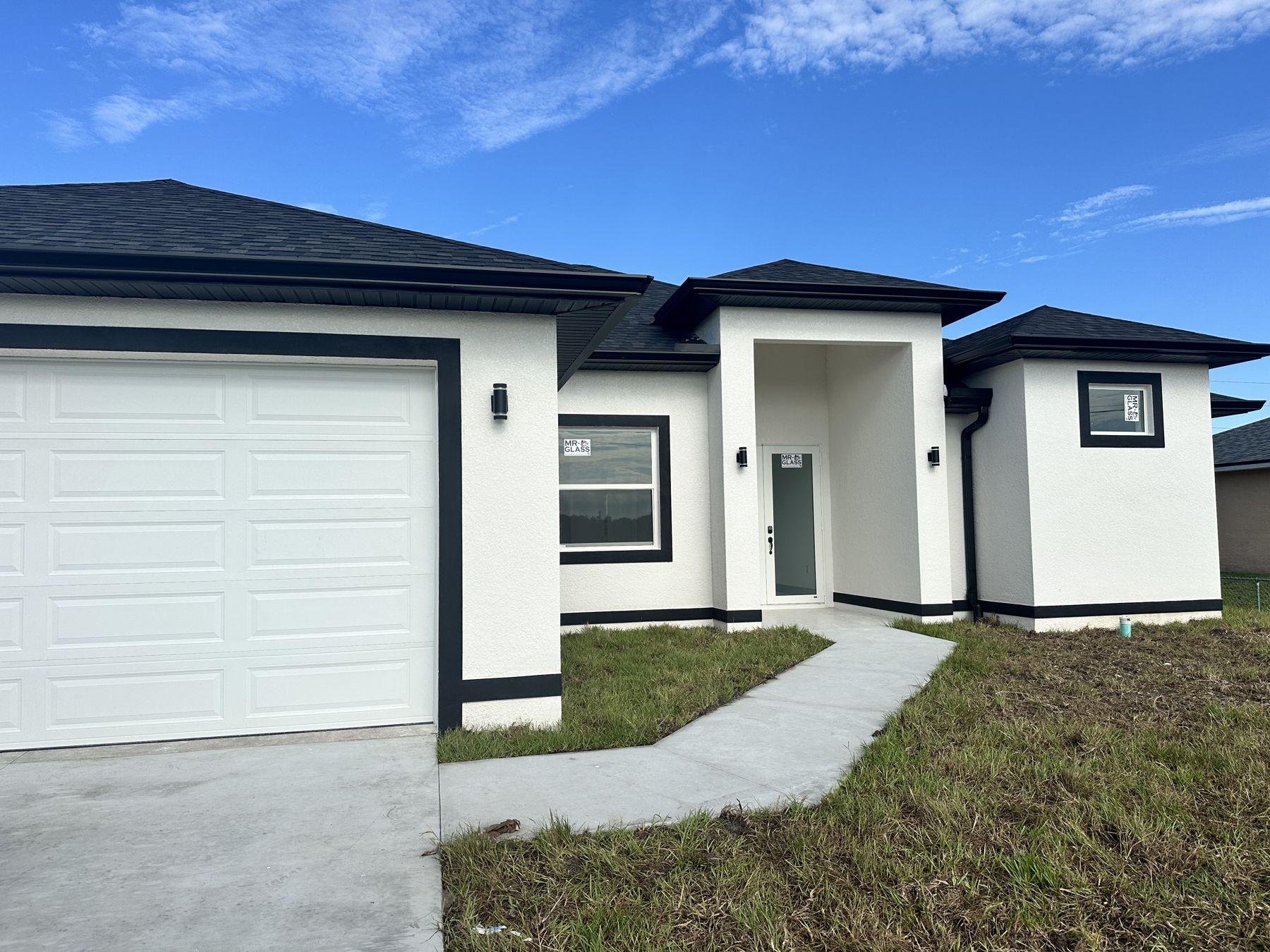 New stucco home with two-car garage and dark trim