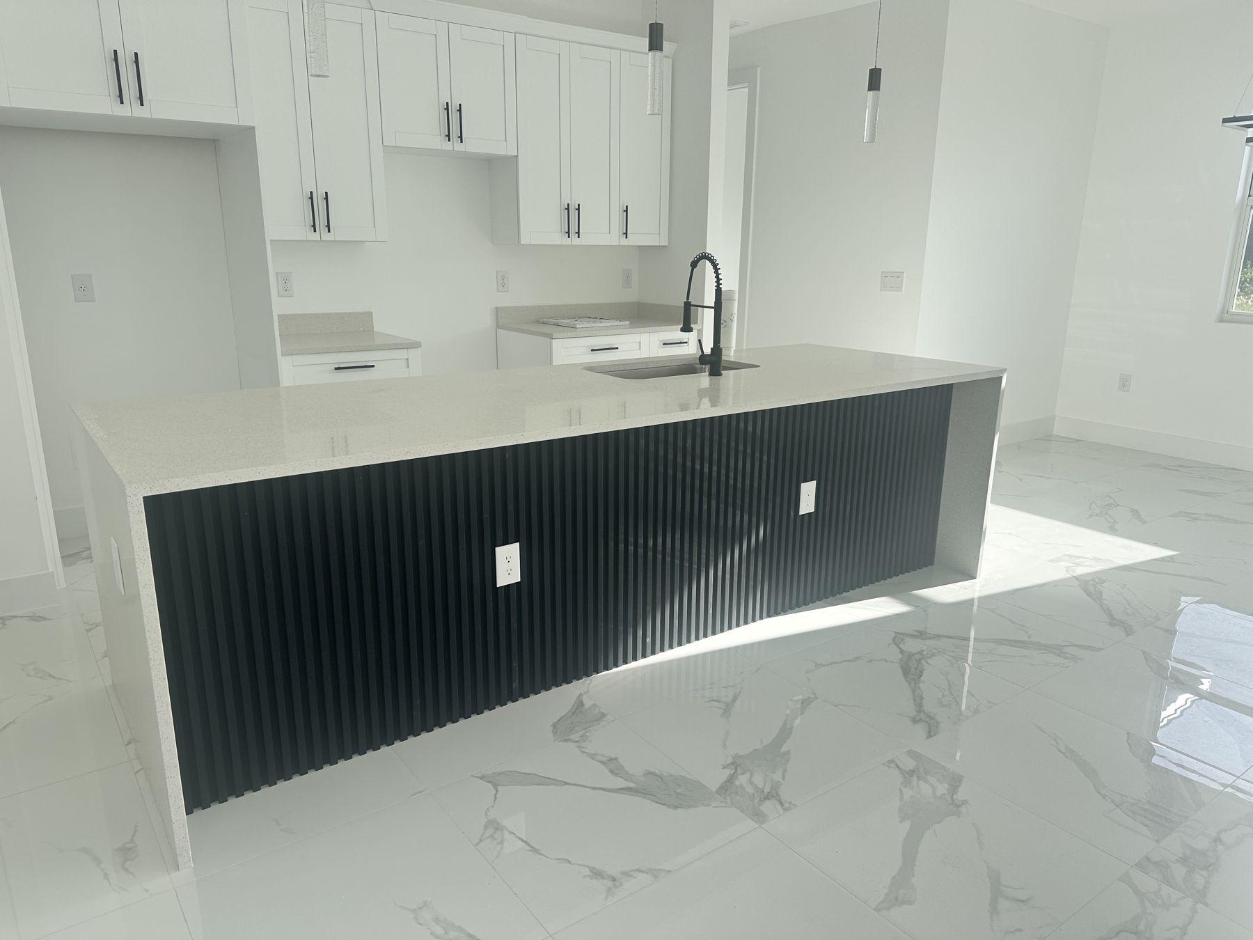 Kitchen with black fluted island and quartz countertop