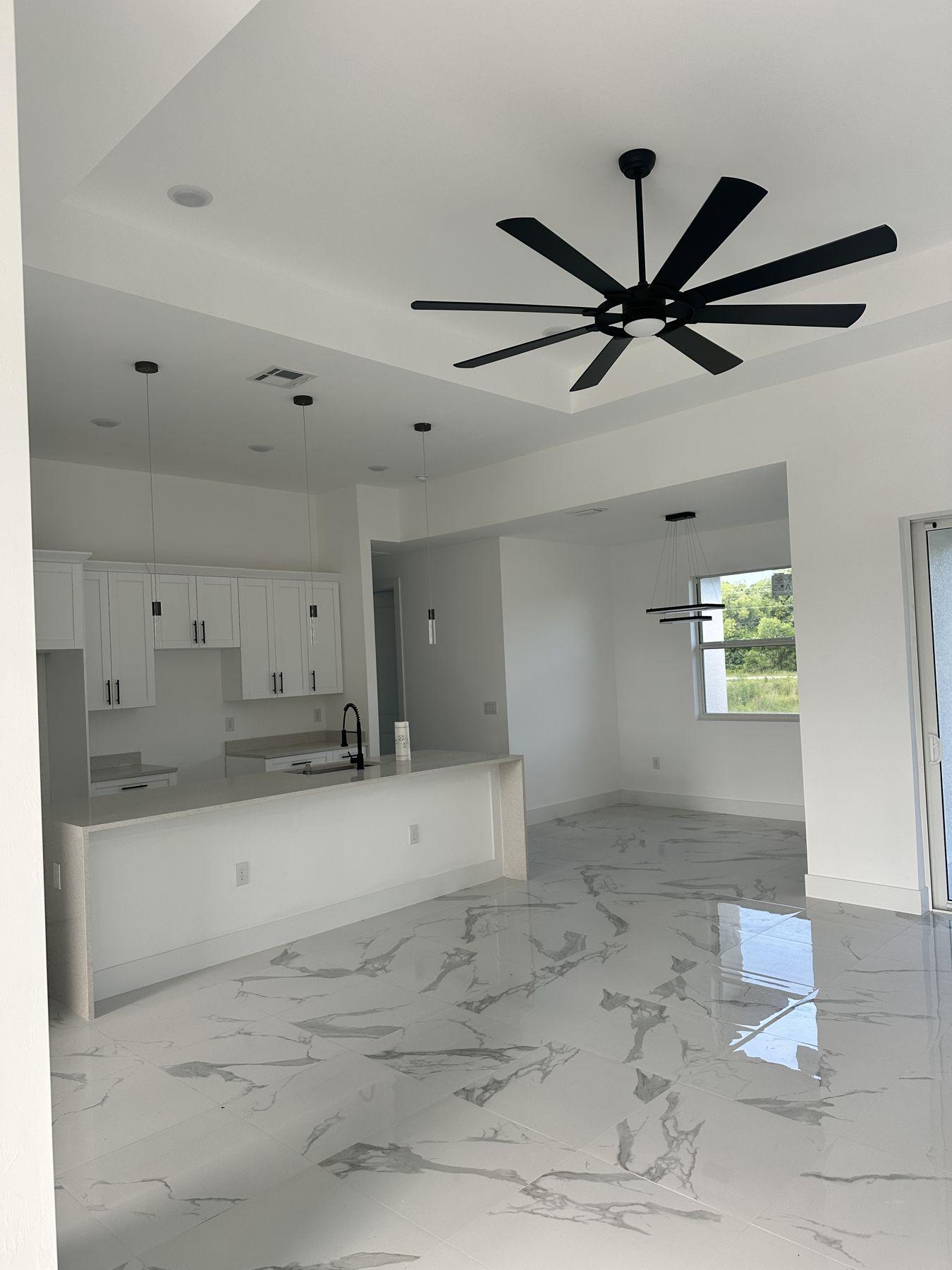Great room with ceiling fan and tray ceiling
