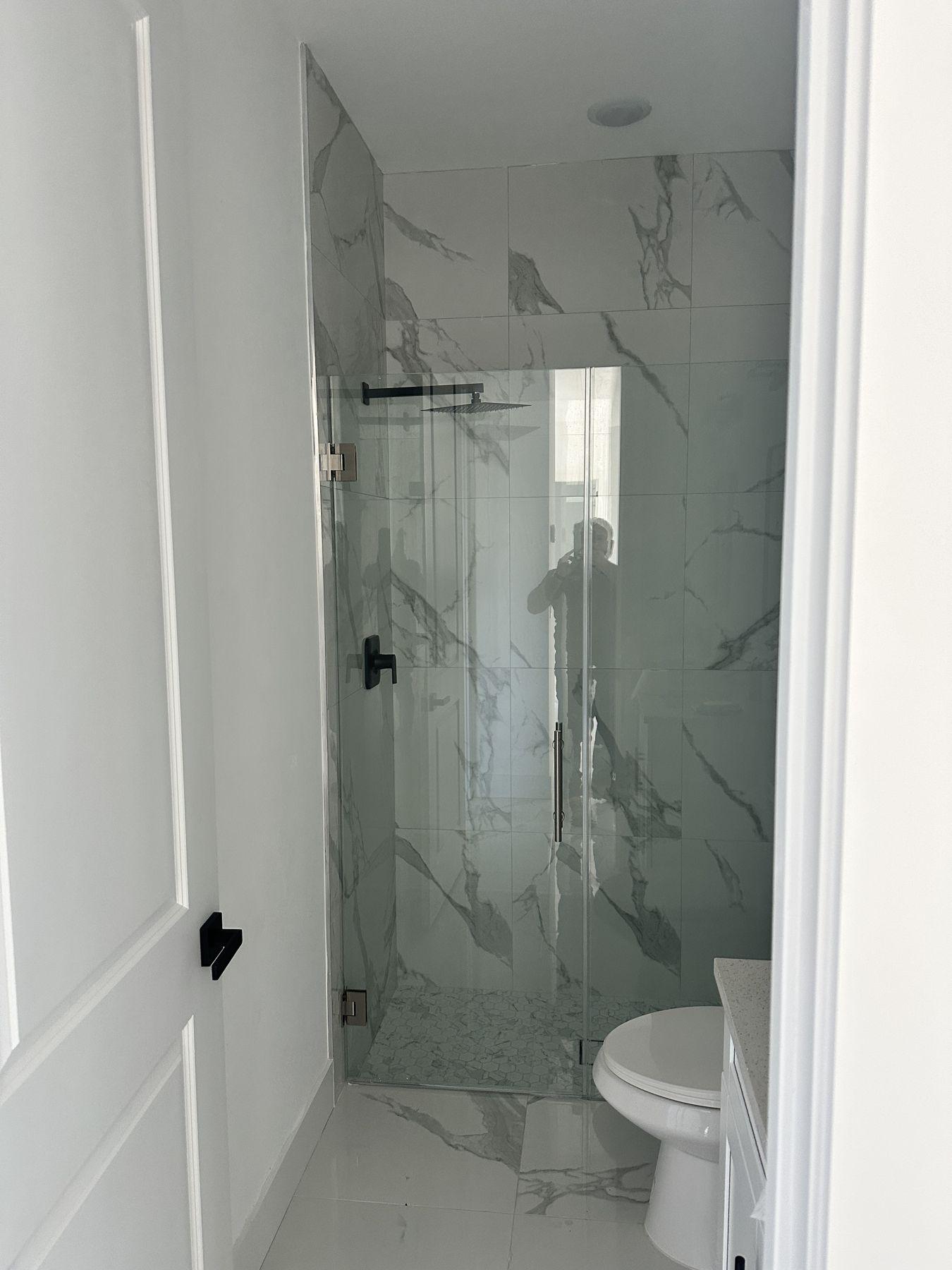 Walk-in shower with frameless glass and marble-look walls