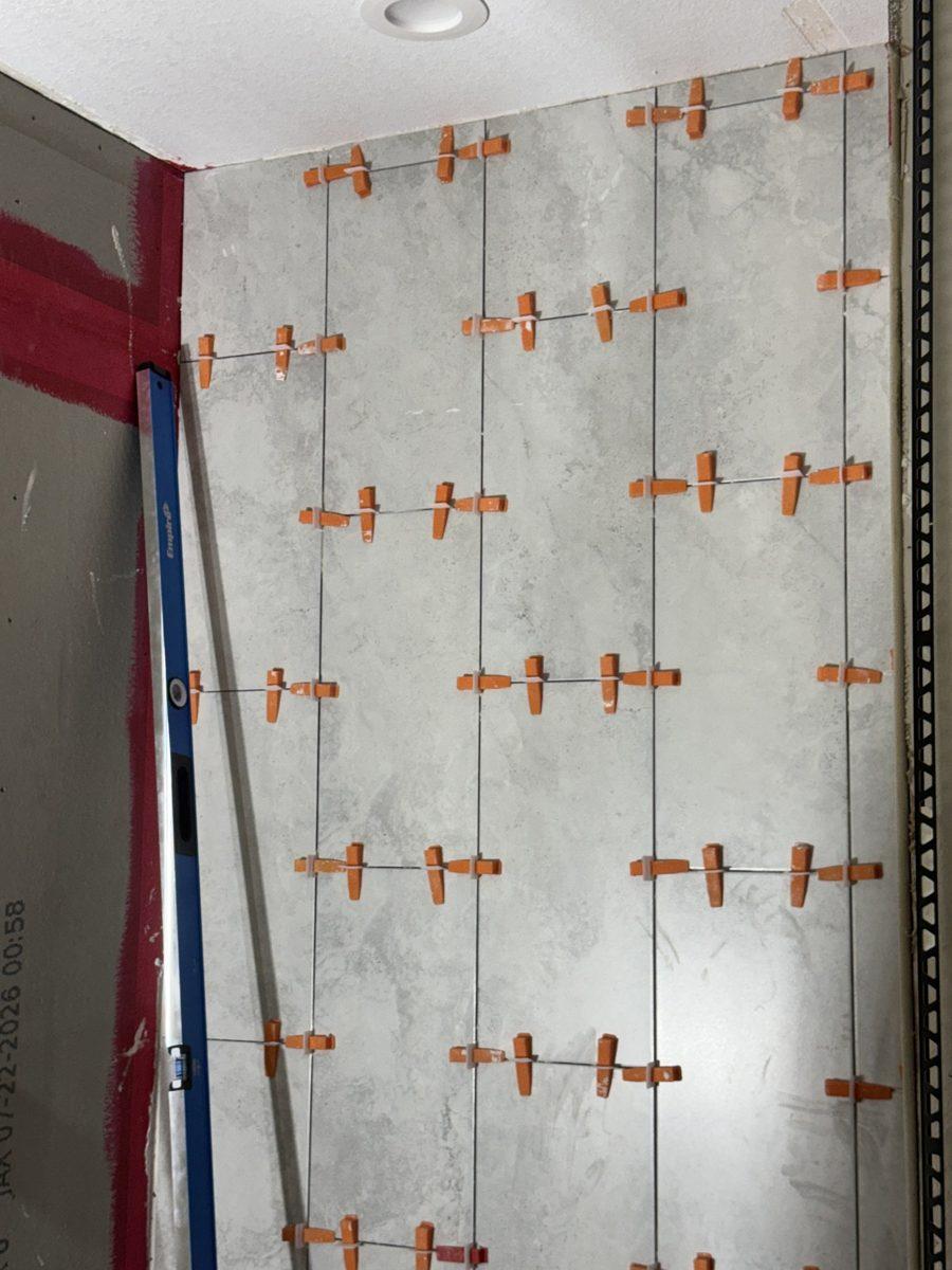 Large porcelain tiles set with orange leveling clips