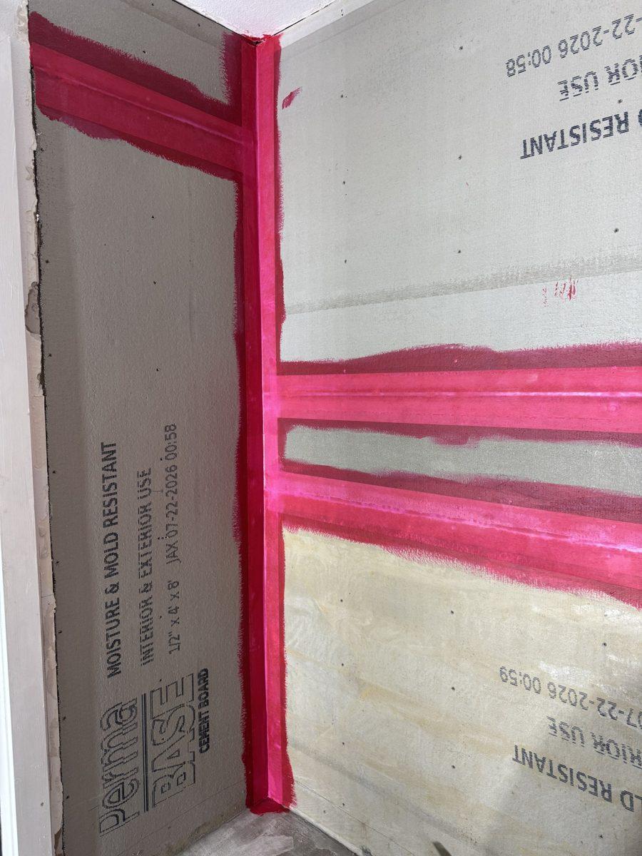 Shower walls in cement board with pink waterproofing on every seam
