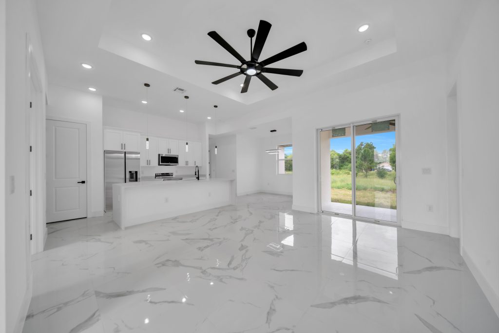 Open-concept kitchen and living room with large-format porcelain tile in a DMG Builders new home